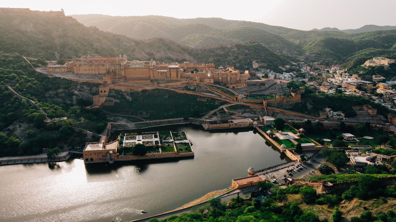 A breathtaking aerial view of Amber Fort, Jaipur with Maota Lake and scenic surroundings.
