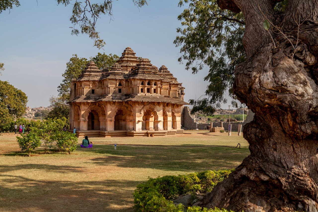 Lotus Mahal in Hampi, India, with surrounding gardens and ancient architecture.